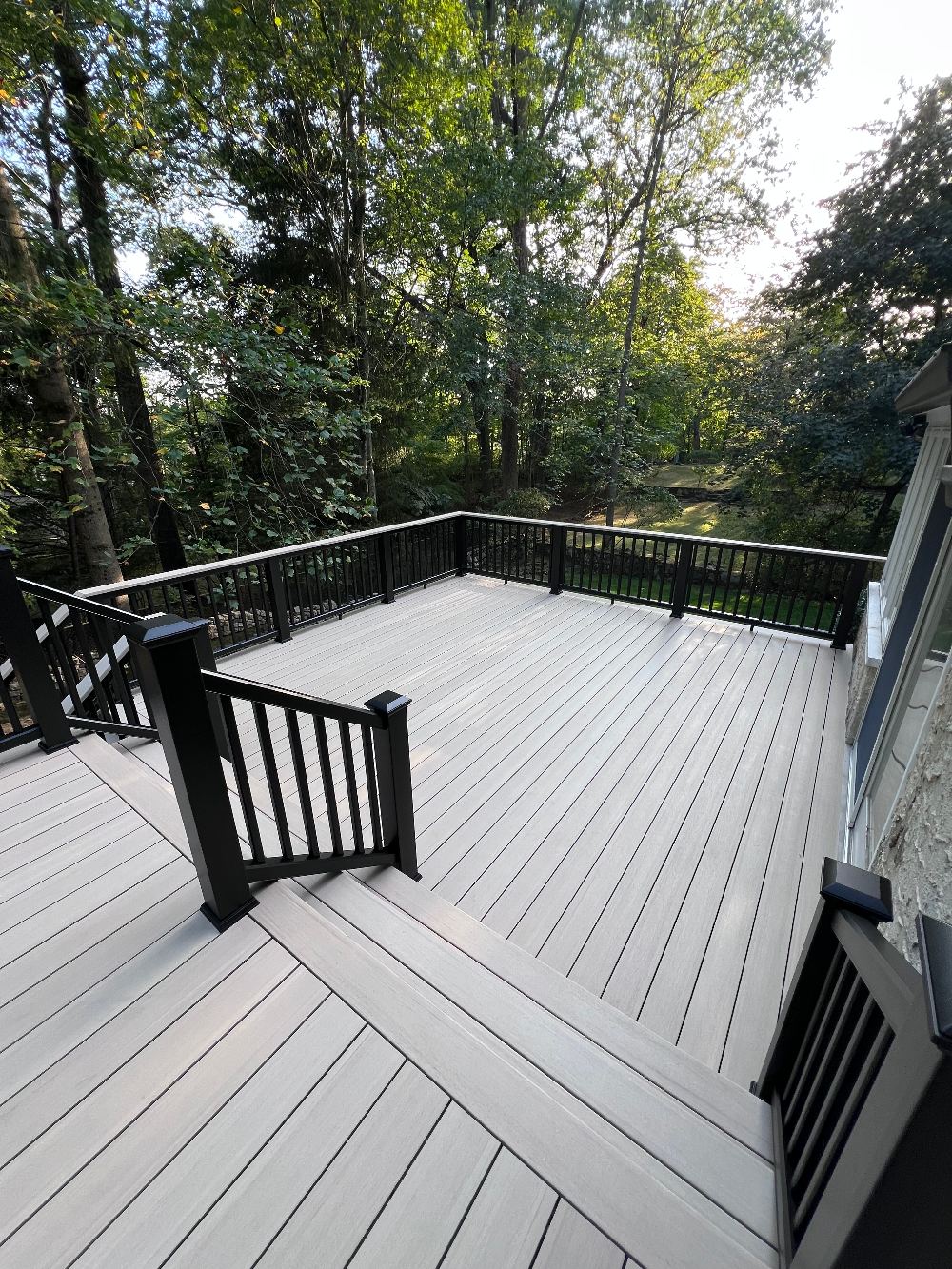 Two-level composite deck with black aluminum railings built in Larchmont, NY