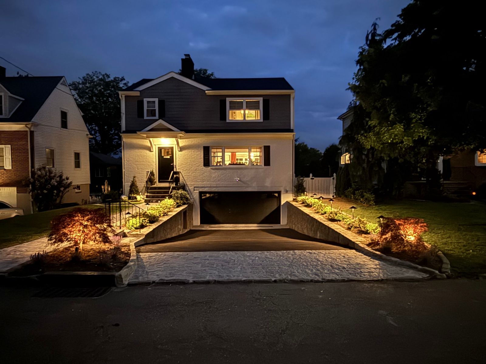 Low voltage landscape lighting with path lights and uplit Japanese maples at a home in Eastchester, NY